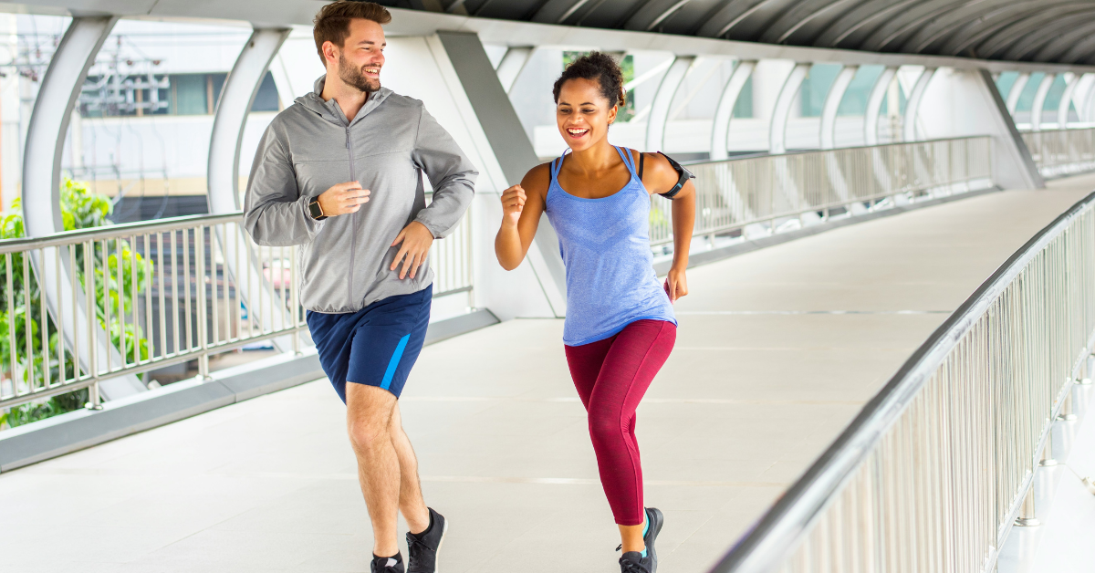 Interracial couple running together over pedestrian bridge