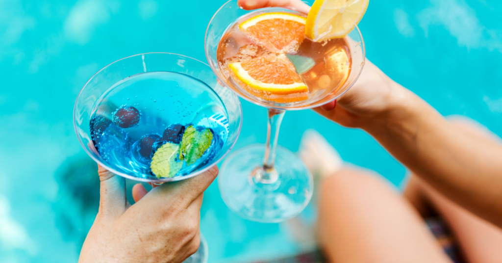 Young couple cheers with colorful cocktails at swingers resort in Mexico