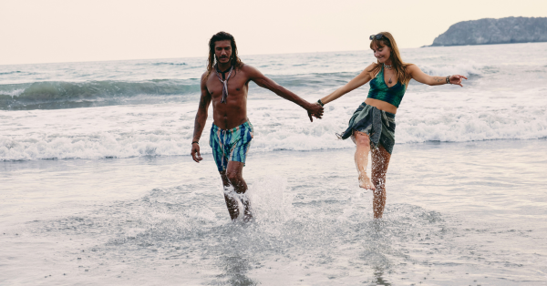 young couple walking in water on the beach at a swingers resort in Mexico