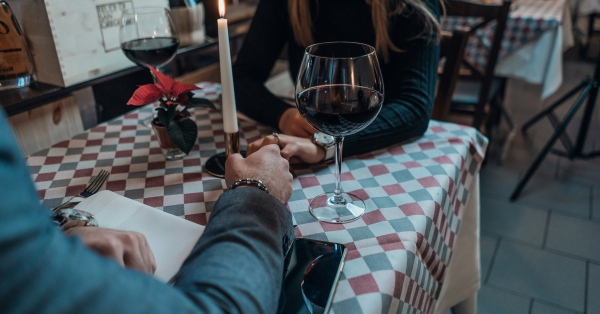 Woman and man holding hands over a table on a romantic date