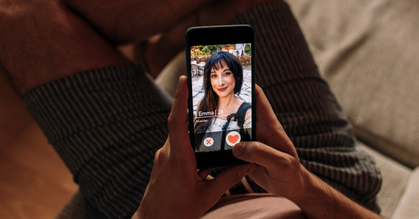 Man sitting down and swiping on a dating app like Tinder